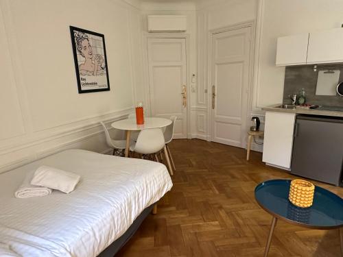 a room with a bed and a table and a kitchen at Luxurious Apartment with AC Promenade des Anglais up to 4 people B in Nice