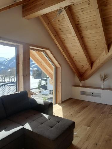 sala de estar con sofá y ventana grande en Bergzauber View en Ramsau am Dachstein