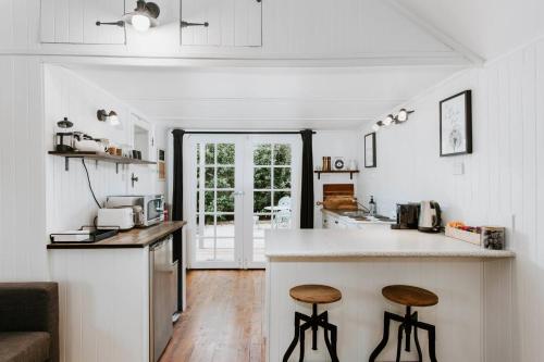a kitchen with a counter and two stools at The Annex - A Cosy Couples Retreat in Heart of Town in Mudgee