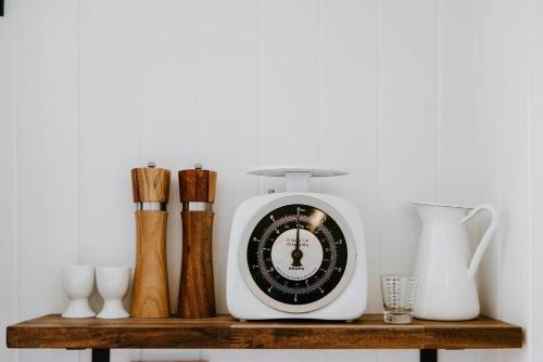 a clock sitting on top of a wooden shelf at The Annex - A Cosy Couples Retreat in Heart of Town in Mudgee