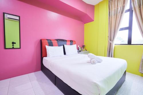 a bedroom with two beds with colorful walls at SY JERANTUT HOTEL in Jerantut