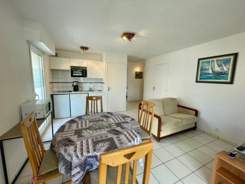 une cuisine et un salon avec une table et des chaises dans l'établissement Appartement T3 48m² centre-ville Quiberon - Plage, commerces, balcon, garage, 4 pers - FR-1-478-224, à Quiberon