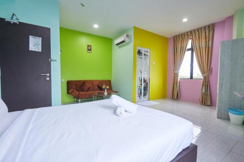 a large white bed in a room with colorful walls at SY JERANTUT HOTEL in Jerantut