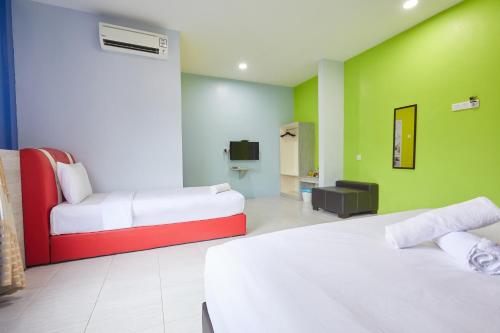 a hotel room with two beds and a tv at SY JERANTUT HOTEL in Jerantut