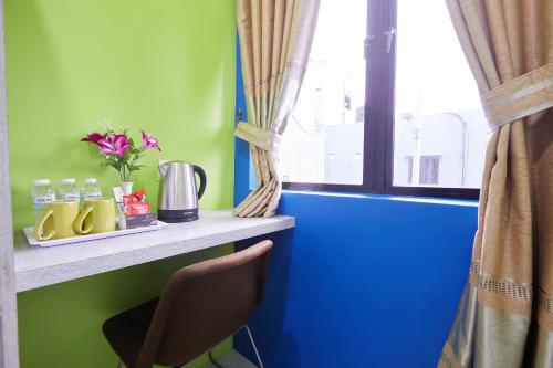 a blue and green room with a counter and a window at SY JERANTUT HOTEL in Jerantut