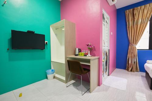a room with a desk and a tv on a wall at SY JERANTUT HOTEL in Jerantut
