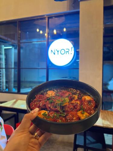 a person holding a bowl of food in a restaurant at HappyNest Hostel Cebu in Cebu City