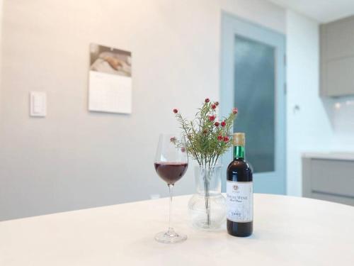 a bottle of wine and a glass of red wine at Stay Ami #GamcheonCultureVillage#Nampodong#Family in Busan