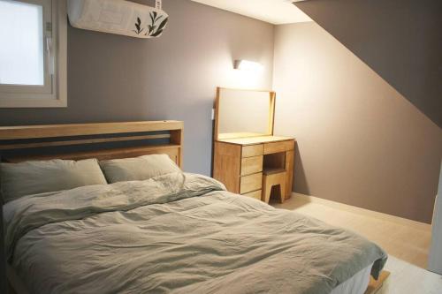 1 dormitorio con 1 cama grande y espejo en Stay Ami #GamcheonCultureVillage#Nampodong#Family, en Busan