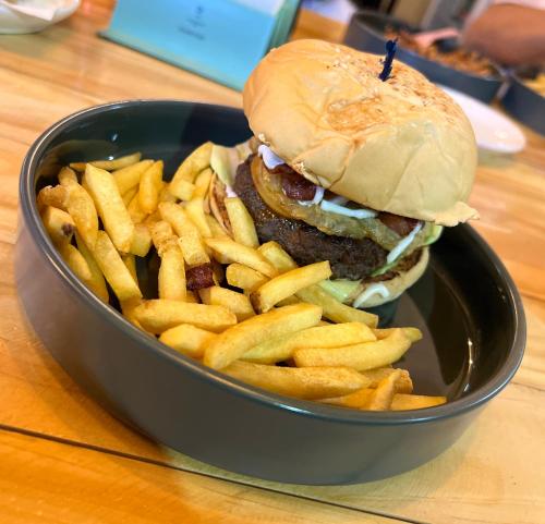 a black bowl with a hamburger and french fries at HappyNest Hostel Cebu in Cebu City
