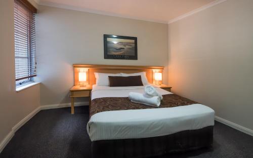 a bedroom with a bed with a towel on it at Napoleon On Kent in Sydney