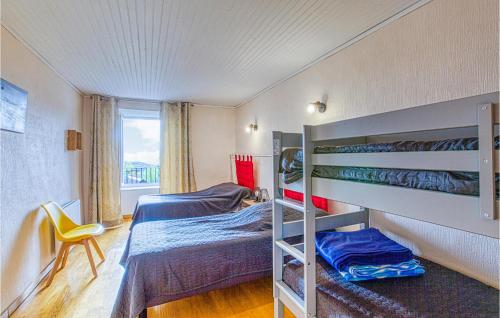 a bedroom with two bunk beds and a yellow chair at Awesome Home In Castelnau-d-mandailles With Outdoor Swimming Pool, Wifi And 2 Bedrooms in Castelnau-de-Mandailles
