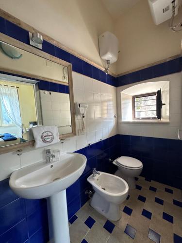 niebiesko-biała łazienka z umywalką i toaletą w obiekcie Guest House Subiaco LA DOMUS w mieście Subiaco