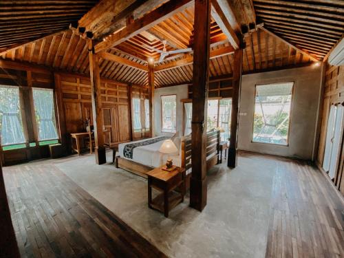 a bedroom with a bed in a room with wooden ceilings at Sarini Villas in Blahbatu