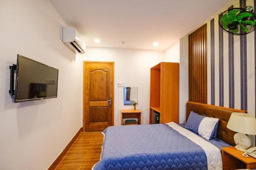 1 dormitorio con 1 cama azul y TV en KHÁCH SẠN TRE VIỆT 2, en Tuy Hoa