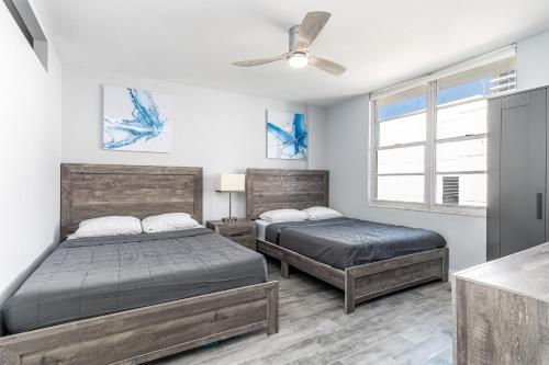 1 dormitorio con 2 camas y ventilador de techo en AMAZING 2BR 2BA NEWLY RENO BEACHFRONT APT W/BEACH VIEW, en Hollywood