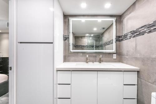 uma casa de banho com um lavatório e um espelho em AMAZING 2BR 2BA NEWLY RENO BEACHFRONT APT W/BEACH VIEW em Hollywood