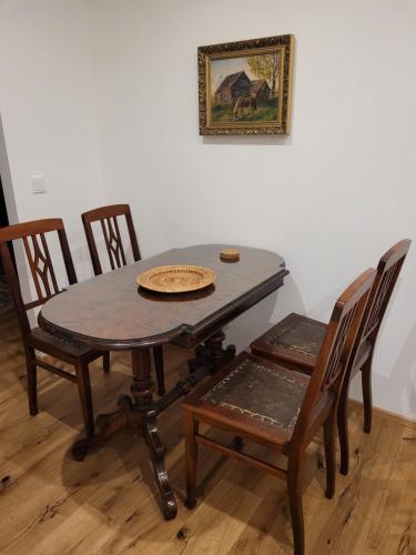 a dining room table with chairs and a picture on the wall at Romantische Ferienwohnung im Grünen in Hohen Neuendorf