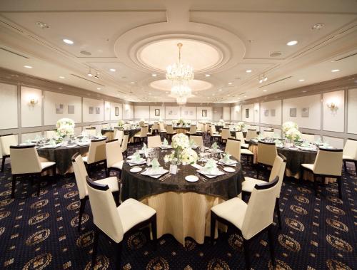 a banquet room with tables and chairs and a chandelier at Hotel Awina Osaka in Osaka