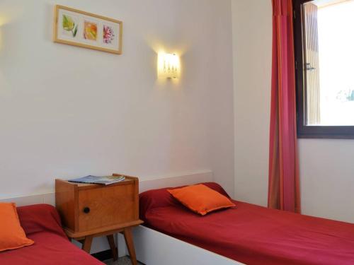 une chambre avec deux lits et une table et une fenêtre dans l'établissement Charmant T2 avec balcon, proche plage Saint Clair, parking, 4 couchages - Le Lavandou - FR-1-251-258, au Lavandou