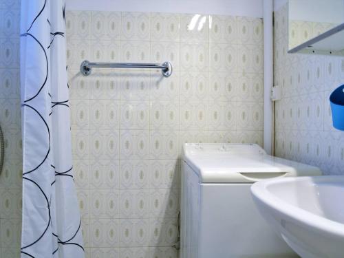 une salle de bain avec un lavabo et une machine à laver dans l'établissement Charmant T2 avec balcon, proche plage Saint Clair, parking, 4 couchages - Le Lavandou - FR-1-251-258, au Lavandou