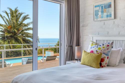 a bedroom with a bed and a view of the ocean at Rontree Reflections in Cape Town