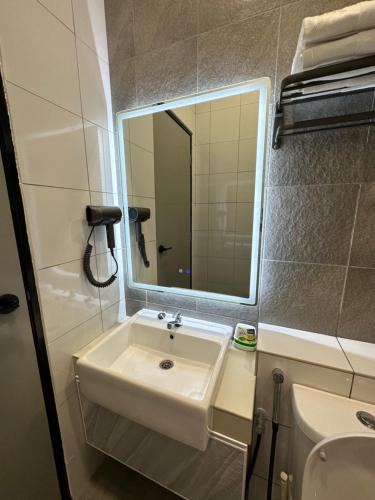 a bathroom with a sink and a mirror at Sandakan SeaView-Suite Top Floor in Sandakan