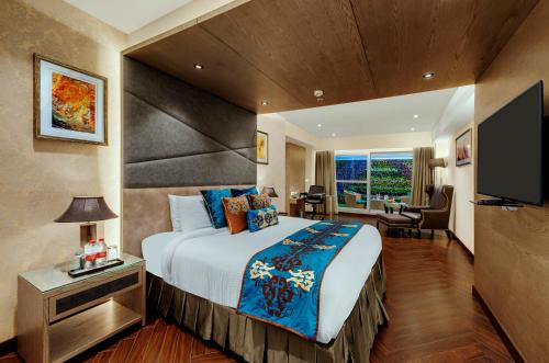 een hotelkamer met een groot bed en een televisie bij Marina- Shimla First Designer Boutique Hotel in Shimla