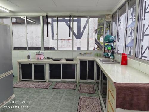 cocina con ventanas, fregadero y encimera en Bani's Penthouse (Homestay Cameron Highlands), en Tanah Rata