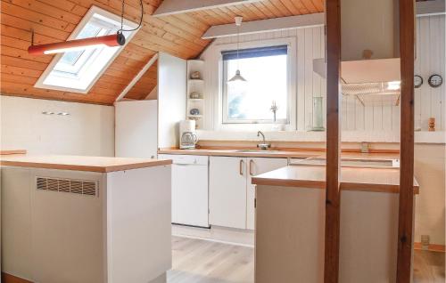 Klegodにある4 Bedroom Pet Friendly Home In Ringkbingの白いキャビネットと木製の天井が備わるキッチン