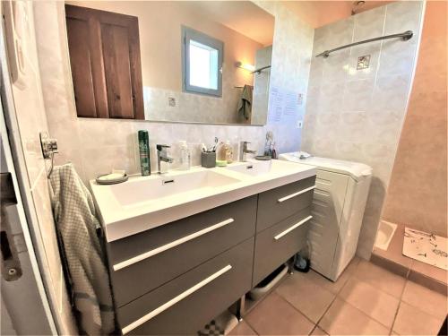 a bathroom with a sink and a toilet and a mirror at Maison Ruoms, 3 pièces, 4 personnes - FR-1-697-2 in Ruoms