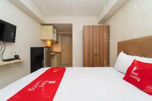 a bedroom with a bed with a red blanket on it at RedLiving Apartemen 19 Avenue - Amanah Room in Tangerang