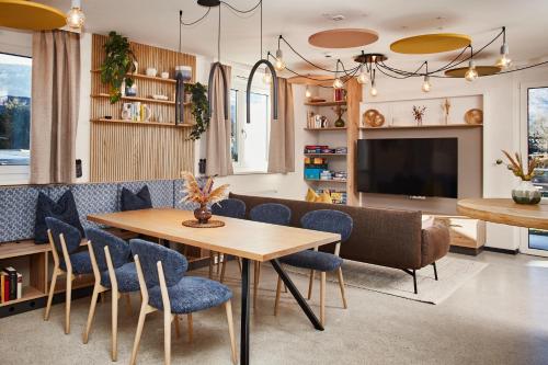 a dining room with a table and chairs and a television at HOMEBOUND APARTMENTS Bad Goisern - contactless check-in in Bad Goisern