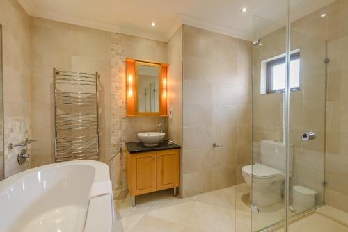 a bathroom with a tub and a toilet and a sink at San Lameer Villa 14205 - 4 Bedroom Luxury - 8 pax -San Lameer Rental Agency in Southbroom