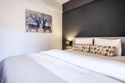 伊斯坦堡的住宿－Chic，卧室配有白色的床和墙上的绘画作品