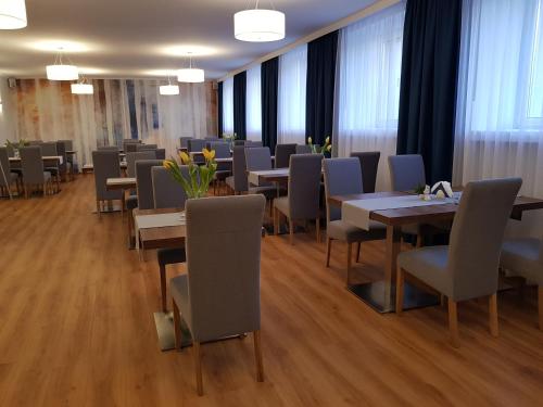 - une salle à manger avec des tables, des chaises et des fenêtres dans l'établissement Brojan, à Jaworzno