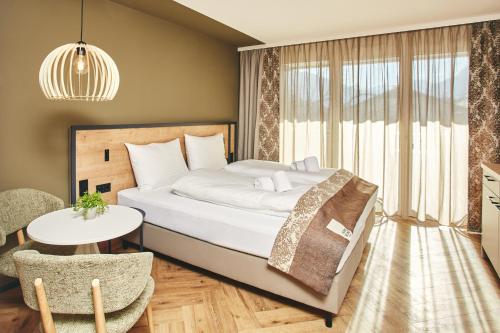 Schlafzimmer mit einem Bett, einem Tisch und Stühlen in der Unterkunft HOMEBOUND APARTMENTS Bad Goisern - contactless check-in in Bad Goisern