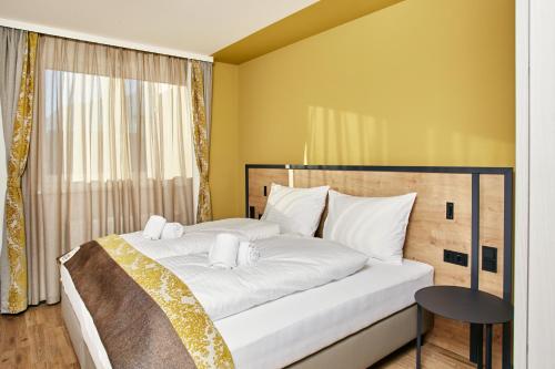 a bedroom with a bed with white sheets and a window at HOMEBOUND APARTMENTS Bad Goisern - contactless check-in in Bad Goisern
