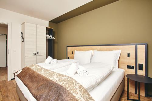 a bedroom with two white beds and a table at HOMEBOUND APARTMENTS Bad Goisern - contactless check-in in Bad Goisern
