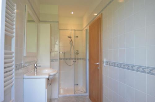 een badkamer met een douche, een wastafel en een douche bij Moderne Ferienwohnung mit eigenem Balkon und gemeinschaftlichen Außenpool in Merano
