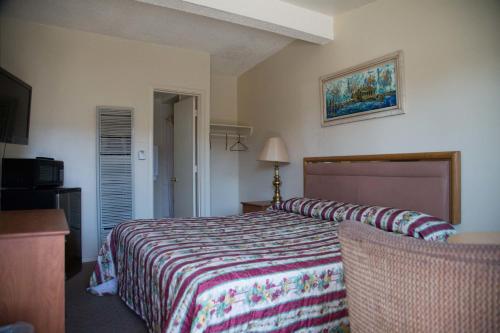 a bedroom with a bed with a colorful bedspread at Boron Motel in Boron