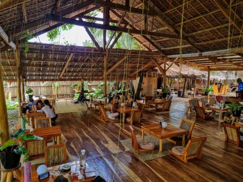 a restaurant with wooden tables and people sitting in it at Wonderland in Siquijor