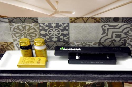 two bottles of essential oils and a book on a shelf at Pine Tree Signature in Chennai