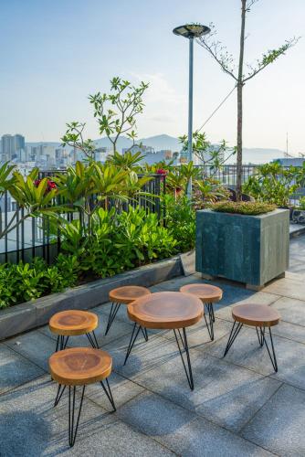 a group of tables and stools on top of a building at Bonny Boutique Hotel Da Nang in Da Nang