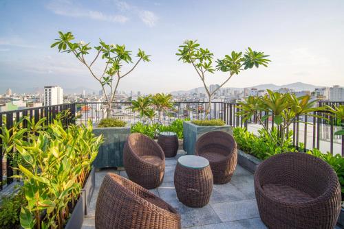 a group of chairs and tables on a balcony at Bonny Boutique Hotel Da Nang in Da Nang