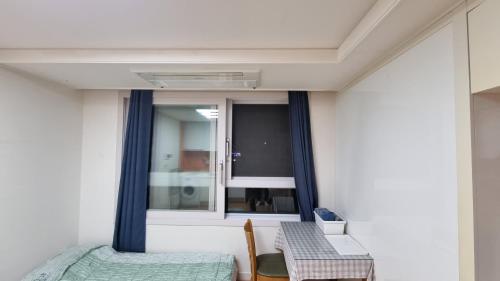 a room with a bed and a window and a table at New world hwani House in Seoul