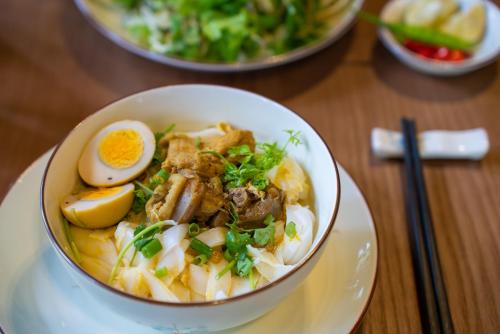 a bowl of food with an egg on a table at Bonny Boutique Hotel Da Nang in Da Nang