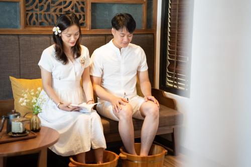 a man and a woman sitting on a bench at Bonny Boutique Hotel Da Nang in Da Nang