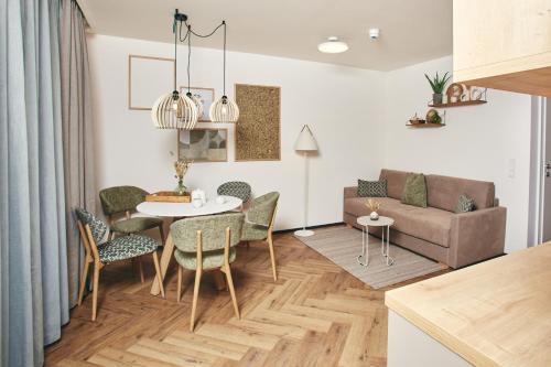 a living room with a table and chairs and a couch at HOMEBOUND APARTMENTS Bad Goisern - contactless check-in in Bad Goisern