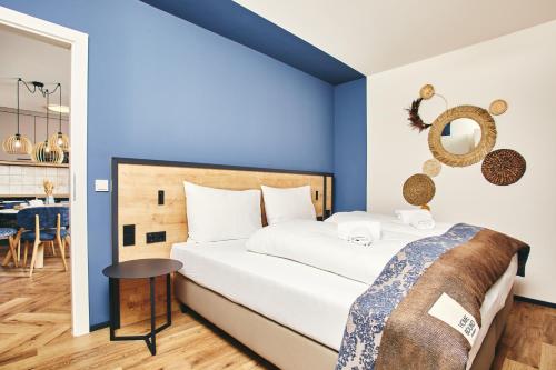 a bedroom with blue walls and a bed with a table at HOMEBOUND APARTMENTS Bad Goisern - contactless check-in in Bad Goisern
